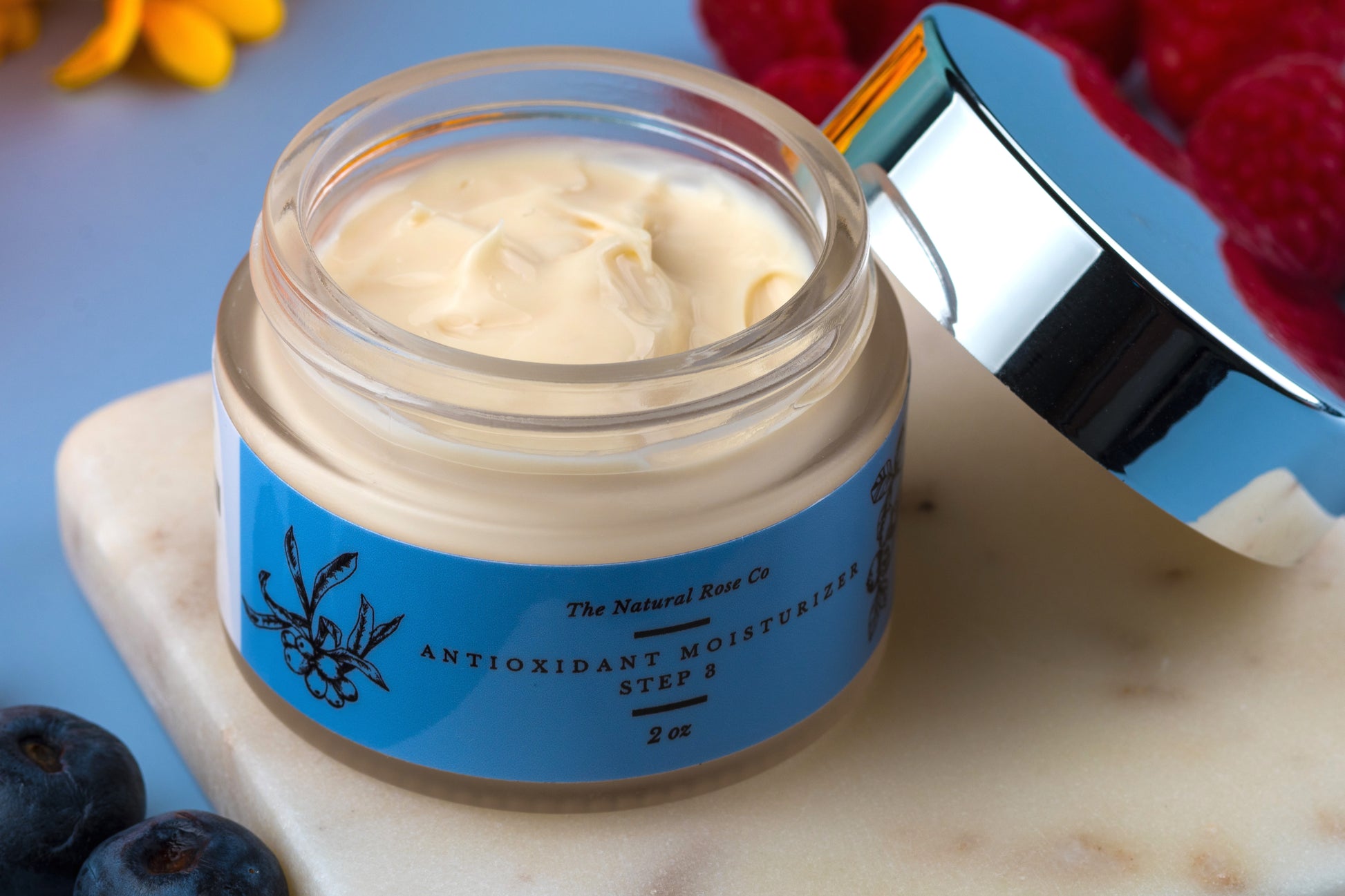 The Natural Rose natural skincare antioxidant cream moisturizer in open jar with silver lid on marble